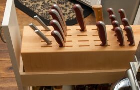 Legacy by Körner Retractable Knife Block with Spice Storage shown in pull-out base cabinet, displaying knife slots and spice racks in organized compartments.