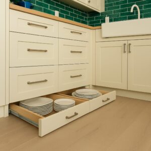 Legacy by Körner Toe kick Drawer built into kitchen base cabinet kick space, open to show hidden storage compartment.