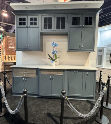Korner cabinetry display at KBIS 2025, featuring a modern blue kitchen cabinet design with white countertop and integrated lighting.